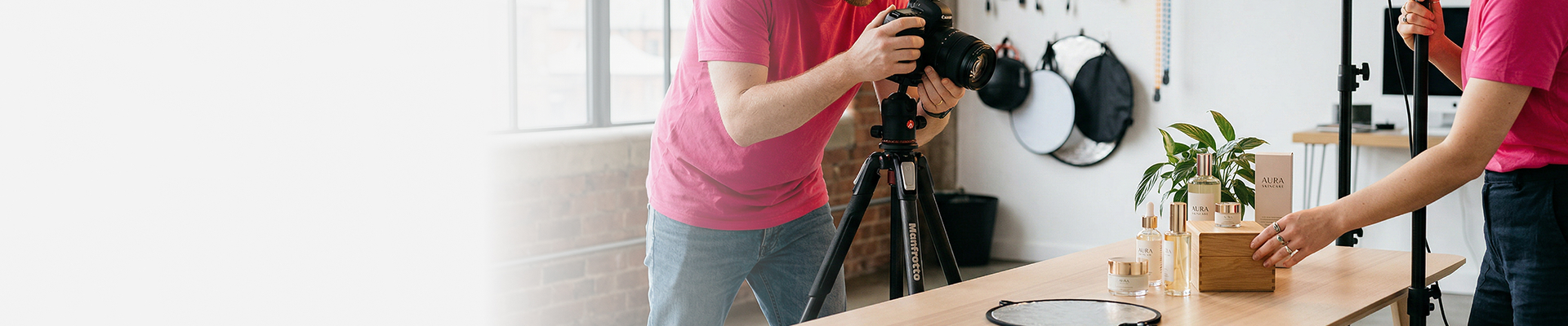 Fotograf und Assistentin richten Produkte für ein professionelles Fotoshooting ein.