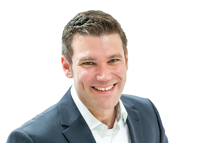 Lächelnder Ansprechpartner im Anzug vor transparentem Hintergrund.